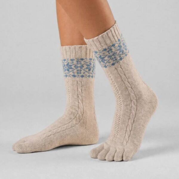 Skarpetki Knitido Merino and Cashmere Snowflakes beige blue - stopy skrzyżowane z boku, pięta uniesiona, palce widoczne