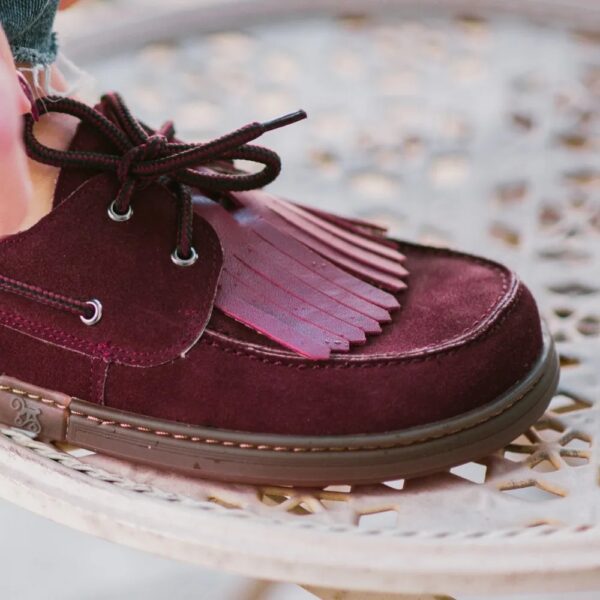 Magical Shoes Galeon burgundy - zbliżenie sznurowania i frędzli, but na stopie przy ażurowym stoliku