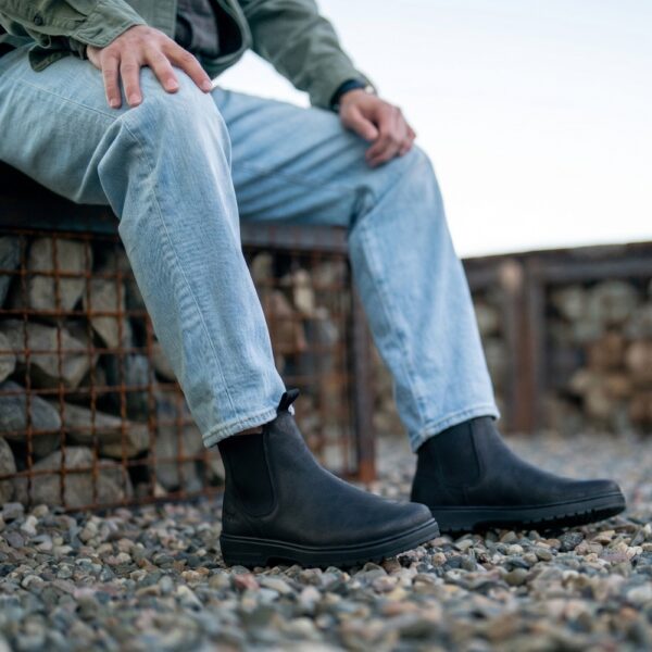 Koel Barefoot Gavien Suede Felt black - mężczyzna siedzi na koszu, stopy w butach na żwirze