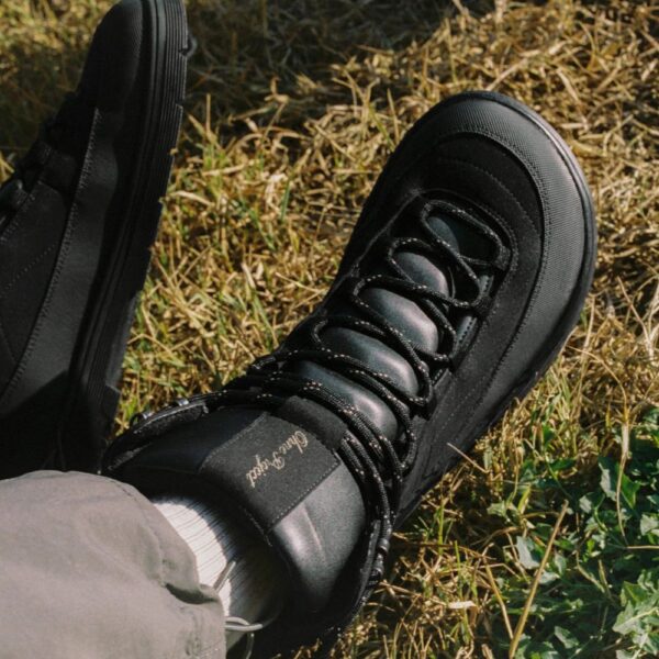 Ohne Project Nomad black - but na nodze widziany z góry na tle suchej trawy