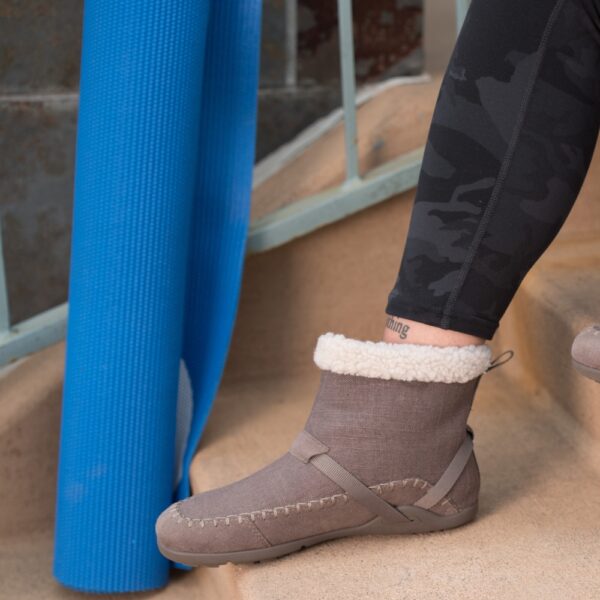 Xero Shoes Ashland Women dark taupe - noga w bucie na schodach, obok zwinięta niebieska mata