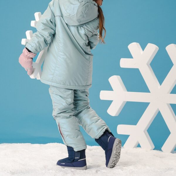 Be Lenka Ailo Kids dark blue - dziecko odwrócone tyłem idzie po śniegu z dekoracją